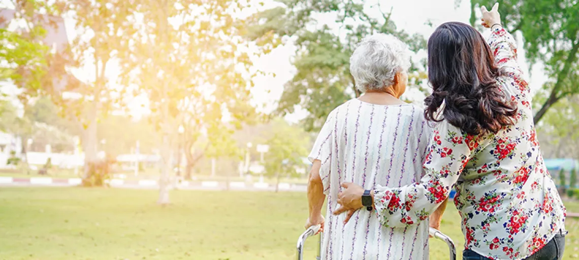 Woman and elderly old lady woman use walker while walking at park